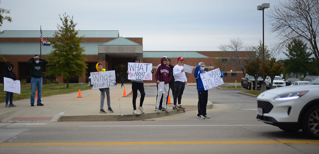 A group of middle schoolers stand in front of Gentry Middle School